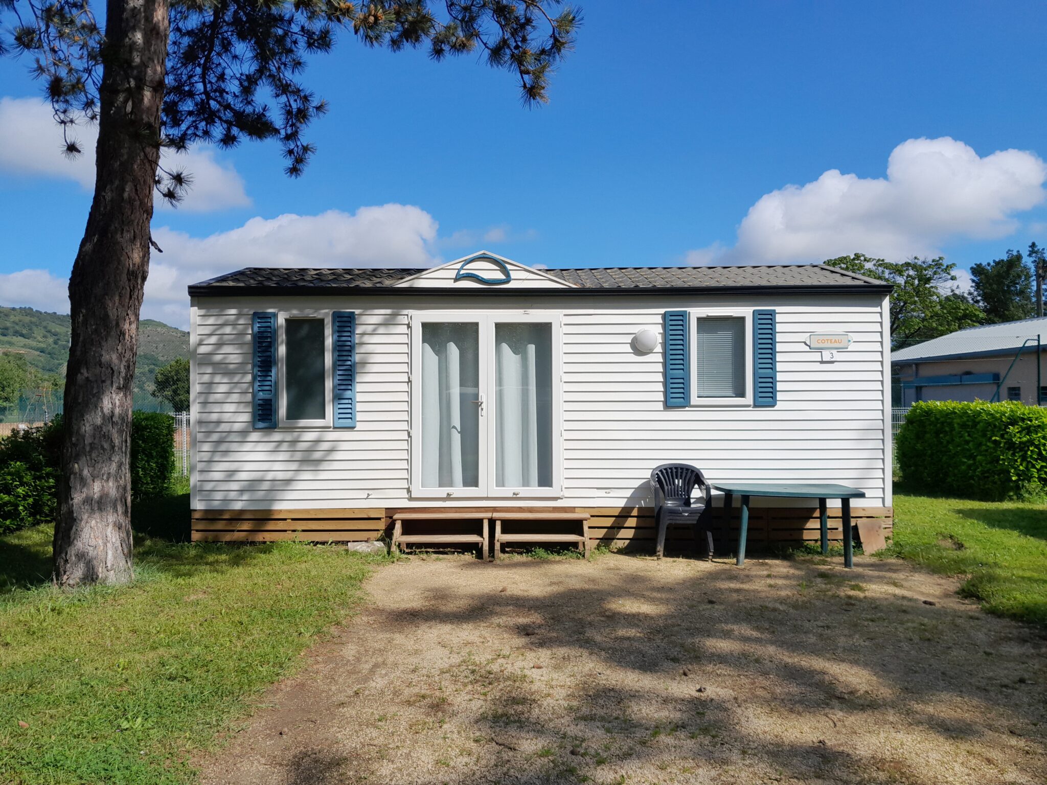 mobil-home type bungalow vue extérieur avec table et chaises pour location de mobil-home à Saint-Vallier