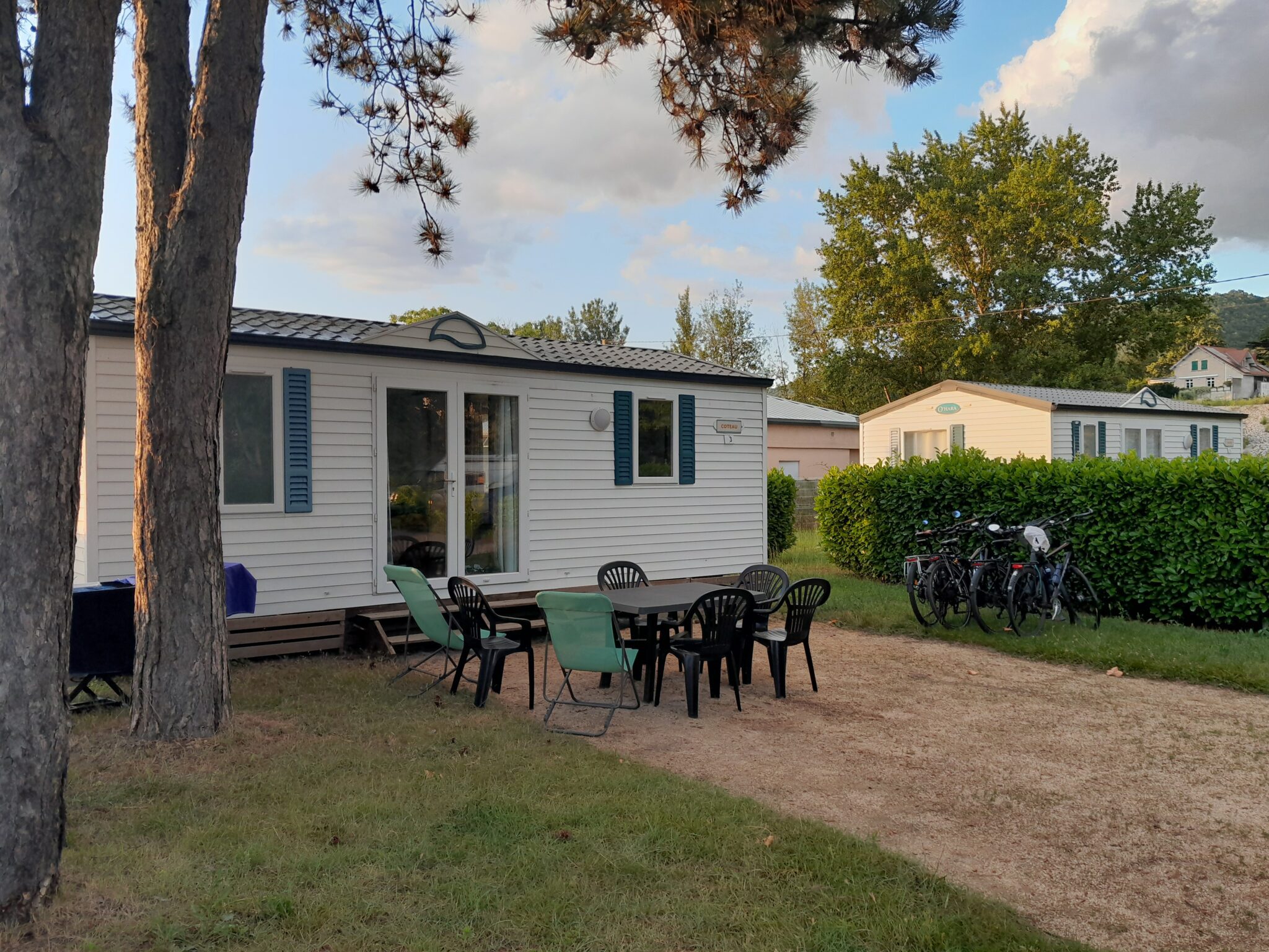 Terasse du mobilhome type bungalow avec table et chaises, vélo. Scène de vie pour location de mobil-home à Saint-Vallier